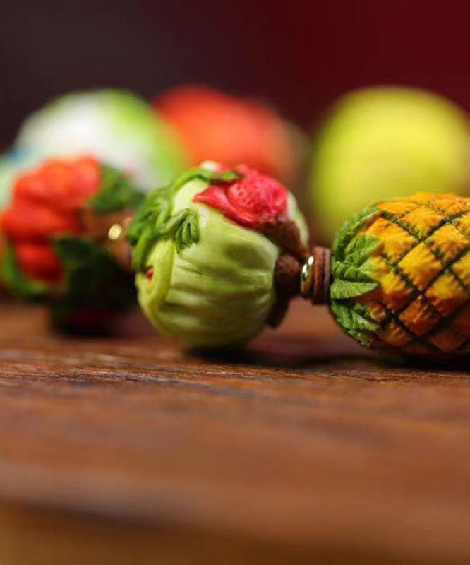 Hermosa pulsera con borlas de frutas y verduras tejida a mano con bloques de color