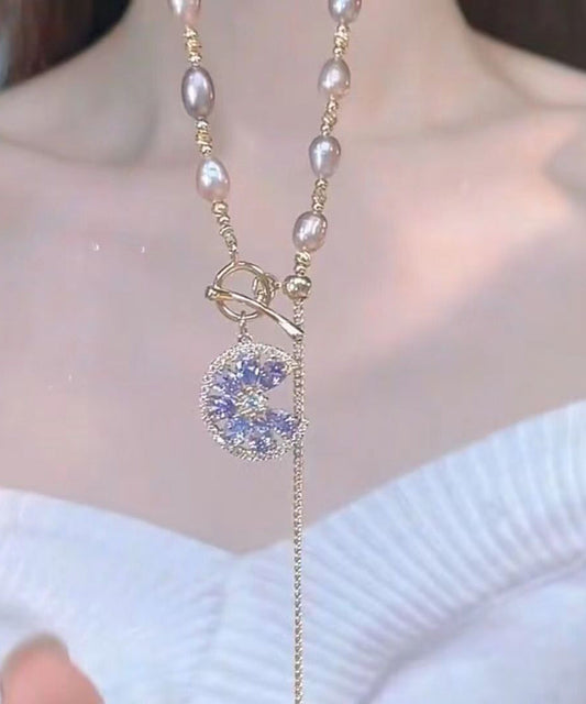 Elegante collar con borla de perlas doradas y cobre morado claro