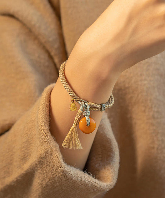 Pulsera fina de borlas de calabaza de cera de abejas tejida a mano en color caqui