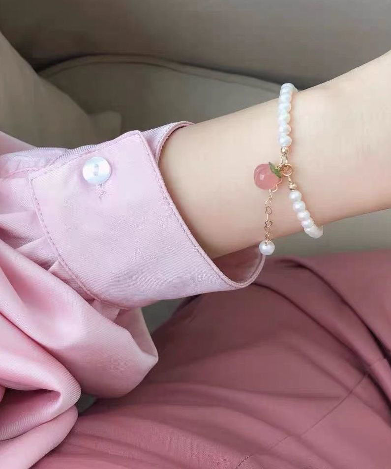 Feines Charm-Armband aus weißer Legierung mit honig-pfirsichfarbenen Perlen