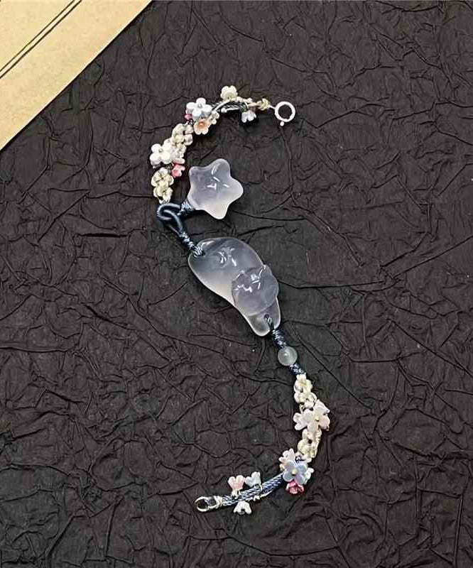 Pulsera con dijes de estrellas y gatos de Osmanthus azul tejida a mano