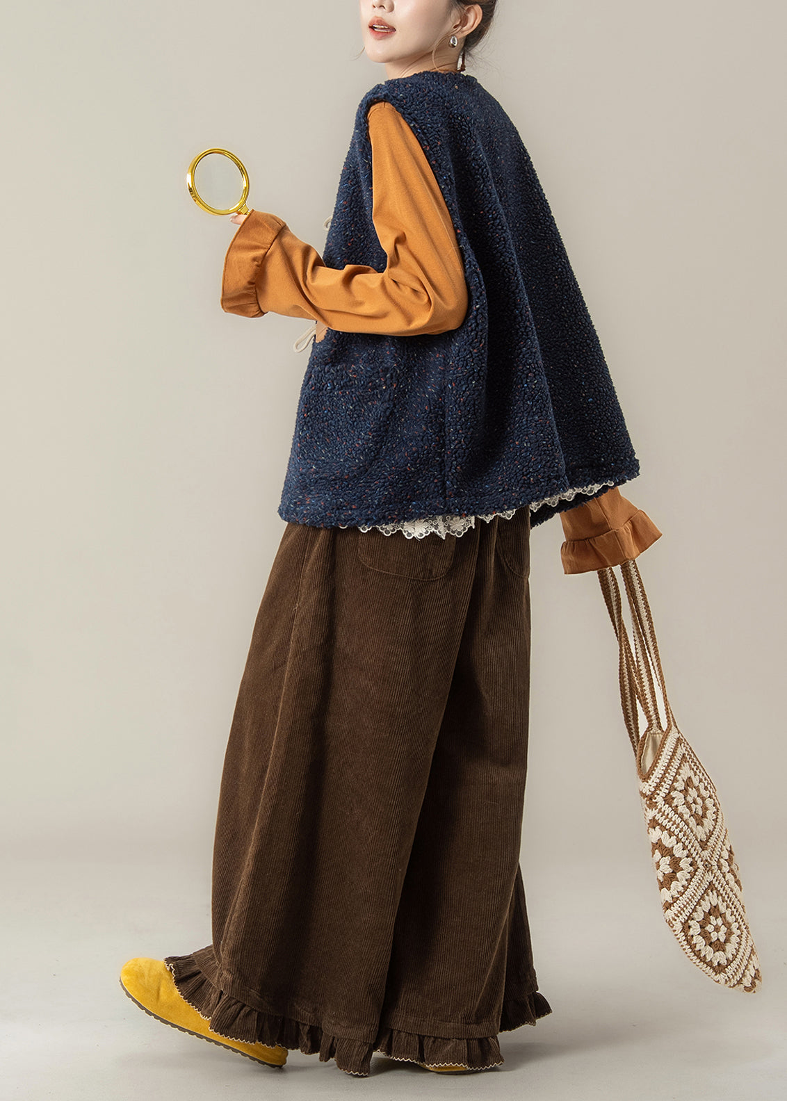 Conjunto de 3 piezas de invierno con chaleco azul marino moderno y camiseta naranja y pantalones café.