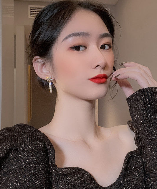 Elegantes pendientes colgantes con borlas y lazo de circonita de aleación de oro