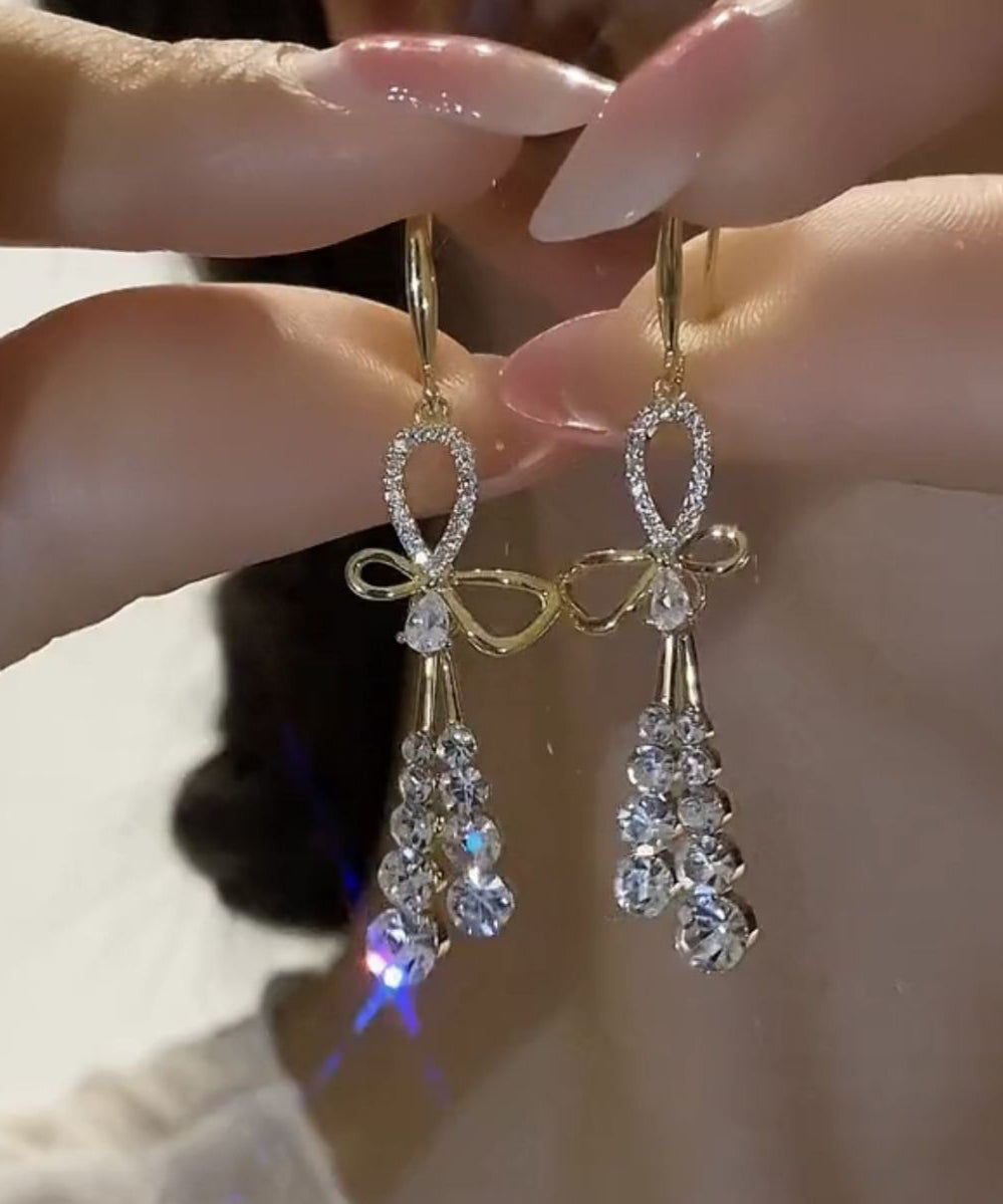 Hermosos aretes colgantes con borlas y lazo de circonitas doradas en plata esterlina