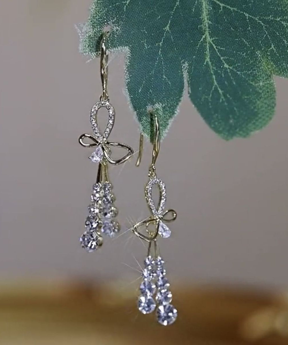 Hermosos aretes colgantes con borlas y lazo de circonitas doradas en plata esterlina