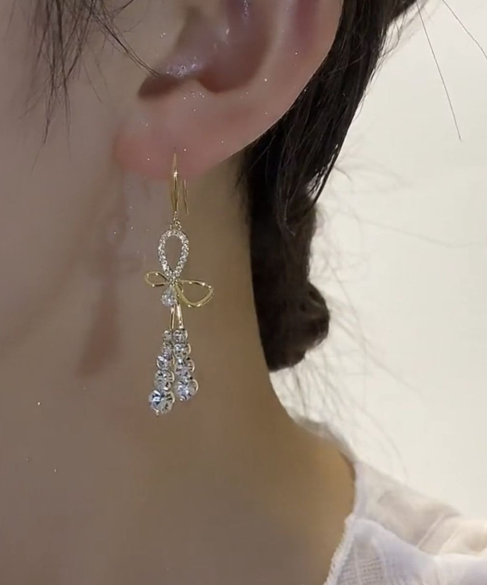 Hermosos aretes colgantes con borlas y lazo de circonitas doradas en plata esterlina