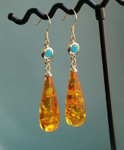 Hermosos aretes colgantes de ámbar naranja con forma de gota de agua