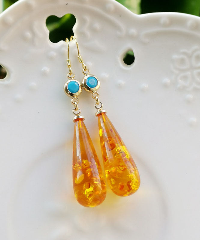 Hermosos aretes colgantes de ámbar naranja con forma de gota de agua