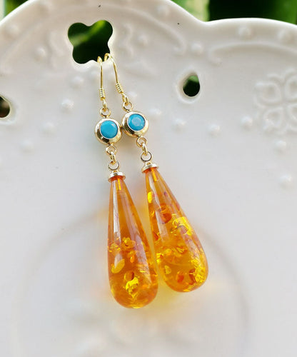 Hermosos aretes colgantes de ámbar naranja con forma de gota de agua