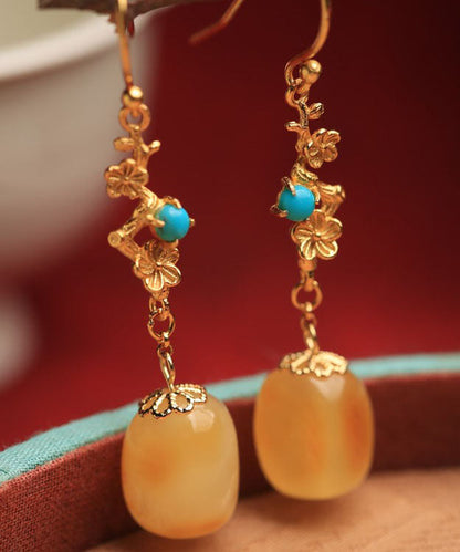 Hermosos aretes colgantes de turquesa y cera de abejas en plata de ley naranja y oro antiguo.