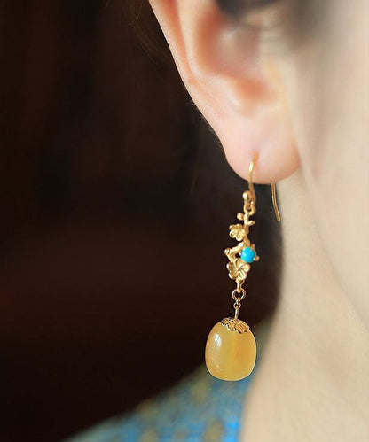 Hermosos aretes colgantes de turquesa y cera de abejas en plata de ley naranja y oro antiguo.