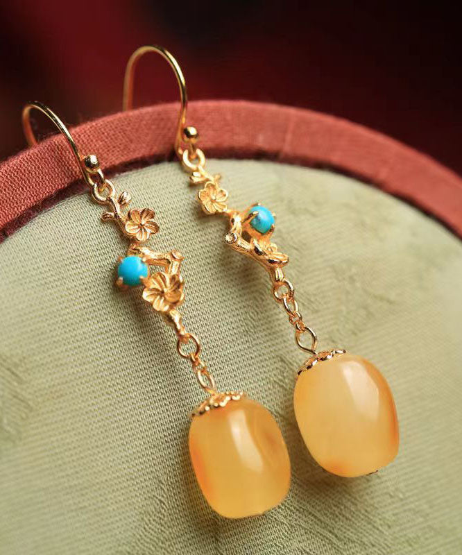 Hermosos aretes colgantes de turquesa y cera de abejas en plata de ley naranja y oro antiguo.