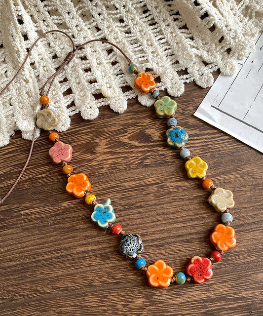 Hermoso collar de cuentas con motivos florales de cerámica con tejido de arcoíris