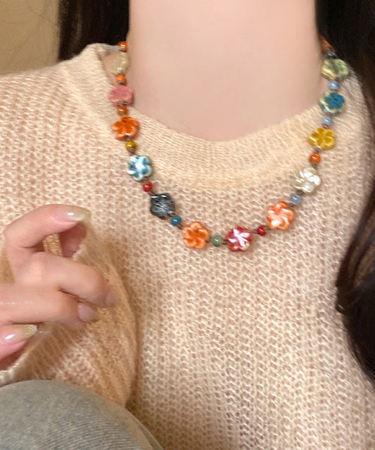 Hermoso collar de cuentas con motivos florales de cerámica con tejido de arcoíris