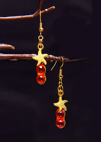 Hermosos aretes colgantes de estrella de mar con gema roja en oro de 14 quilates