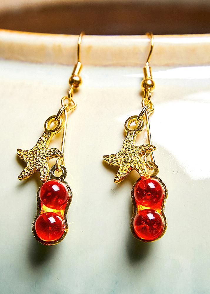 Hermosos aretes colgantes de estrella de mar con gema roja en oro de 14 quilates