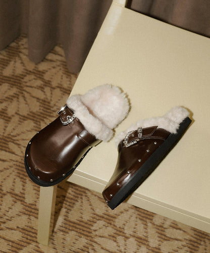 Zapatillas negras de piel sintética con remaches elegantes y forro de lana afelpada.