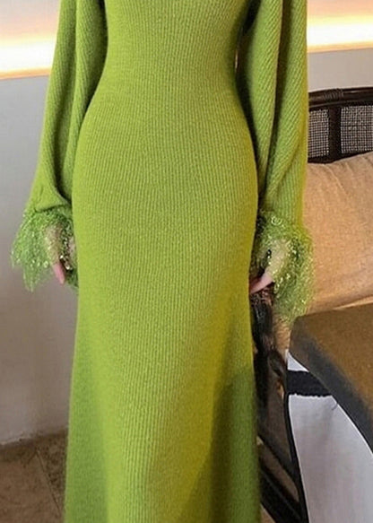 Zweiteiliges Set aus grünem Patchwork-Strickjacke und Maxikleid im Boho-Stil mit ausgestellten Ärmeln, Neckholder und Strickdetails.