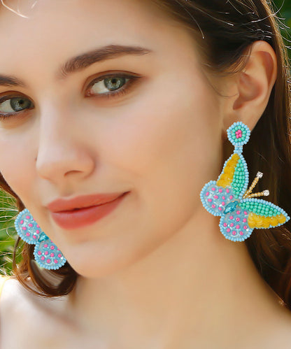 Boutique Ohrringe mit Reisbällchen und Schmetterlingen aus Strickstoff, Blau