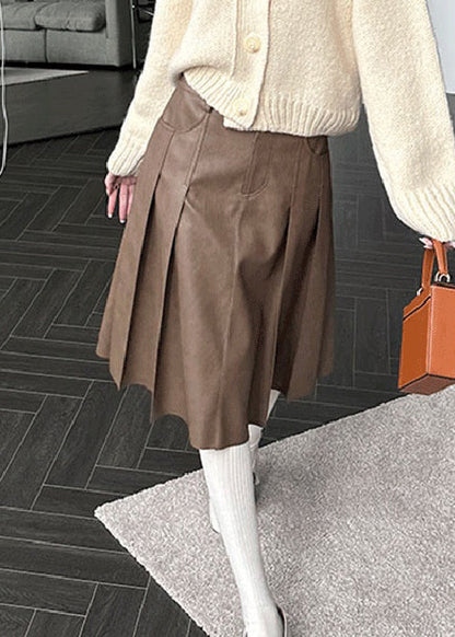 Brauner, hochtaillierter Faltenrock aus Kunstleder mit Knöpfen und Taschen