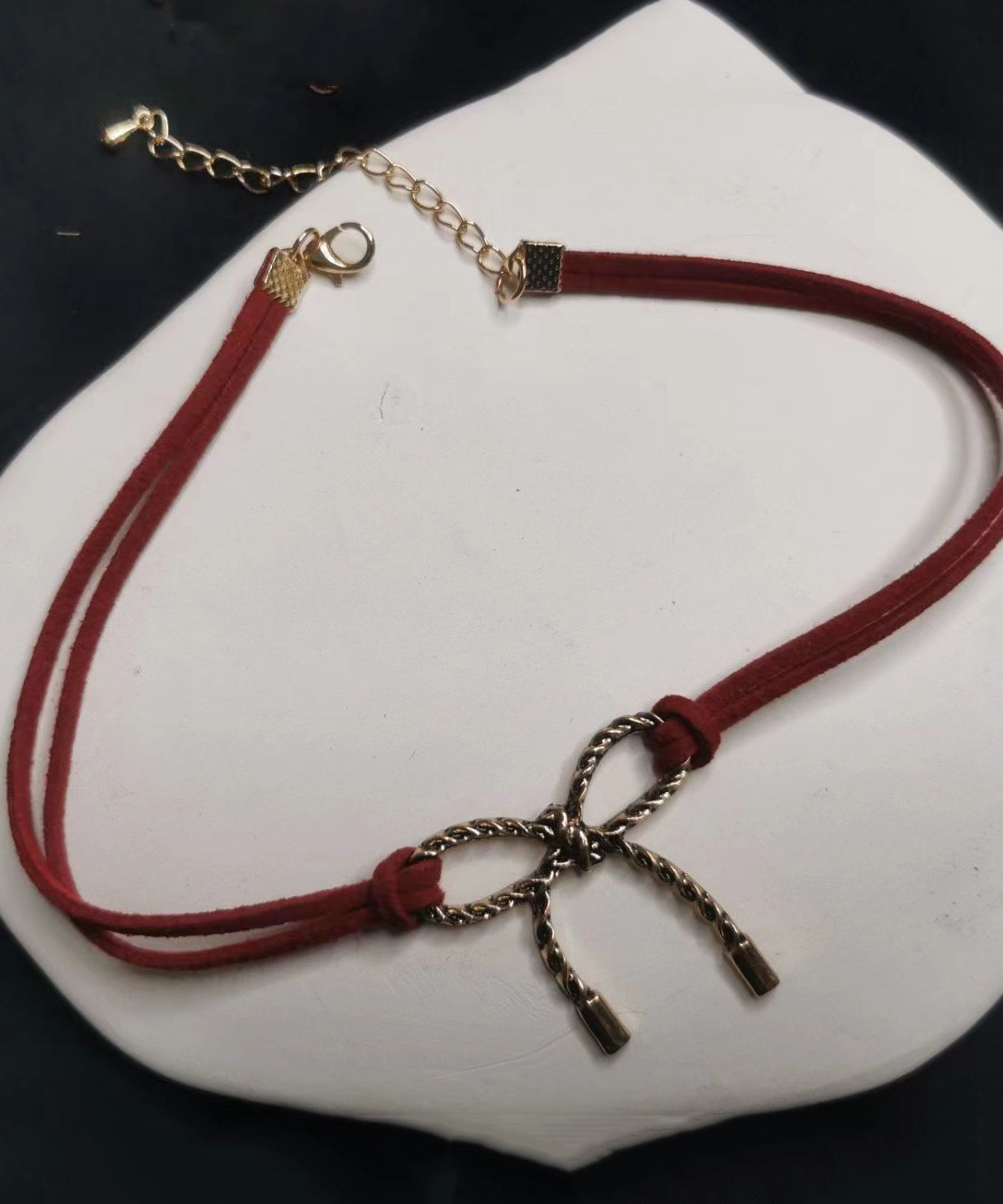 Schicke Halskette mit schwarzem Schleifenanhänger in Schwarz und Gold