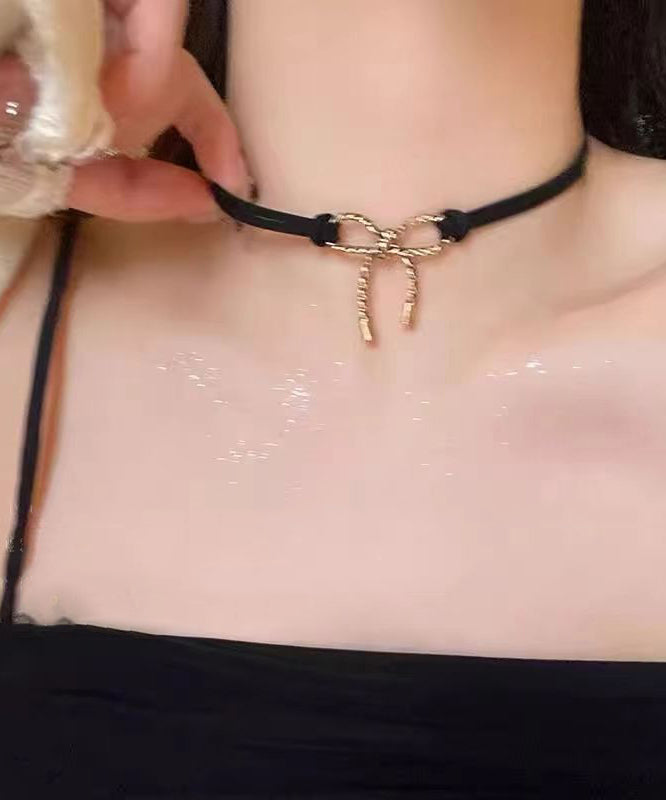 Schicke Halskette mit schwarzem Schleifenanhänger in Schwarz und Gold