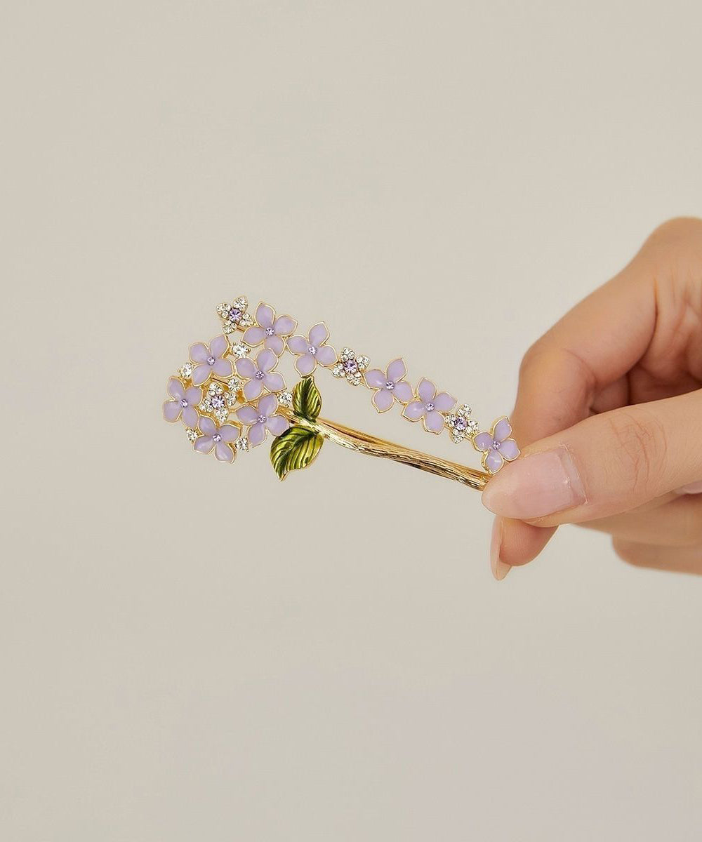 Elegante, asymmetrische Haarnadel mit Blumenmuster aus asymmetrischem Blumenmuster, verziert mit Zirkonkristallen aus einer Legierung aus Lila und Goldlegierung.