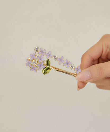 Elegante, asymmetrische Haarnadel mit Blumenmuster aus asymmetrischem Blumenmuster, verziert mit Zirkonkristallen aus einer Legierung aus Lila und Goldlegierung.