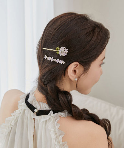 Elegante, asymmetrische Haarnadel mit Blumenmuster aus asymmetrischem Blumenmuster, verziert mit Zirkonkristallen aus einer Legierung aus Lila und Goldlegierung.