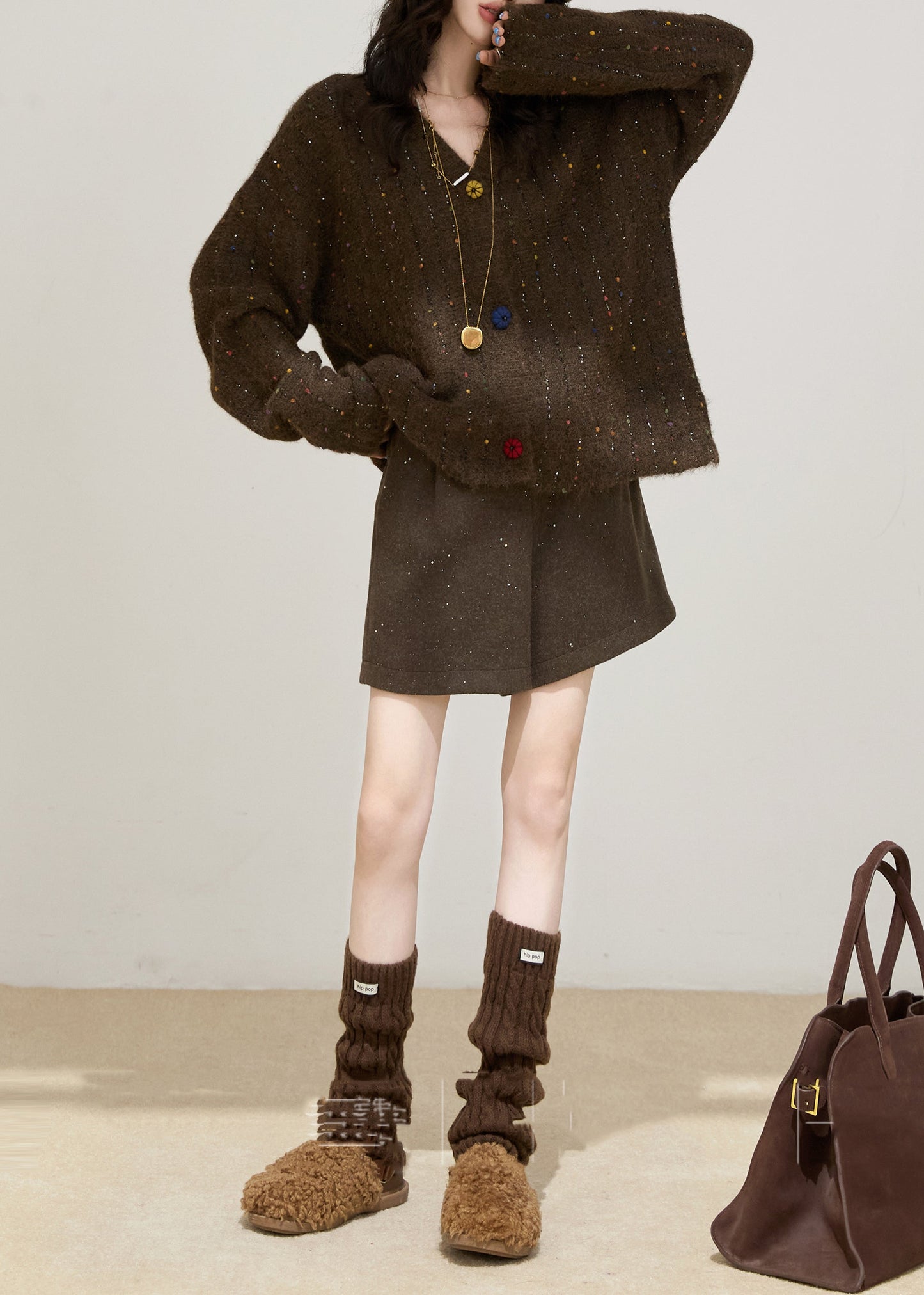 Gemütlicher grauer Oversize-Strickpullover mit bunten Knöpfen für den Winter