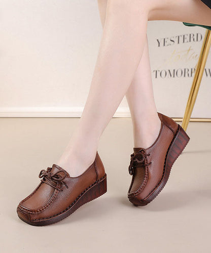 Braune Schuhe mit überkreuzten Riemen und hohem Keilabsatz