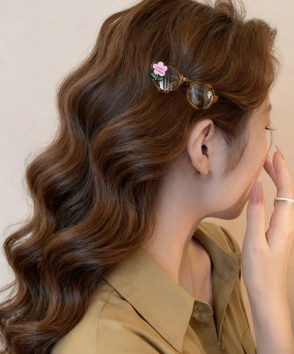 Bonitas gafas de acrílico rosa con diseño floral y horquilla para el pelo.
