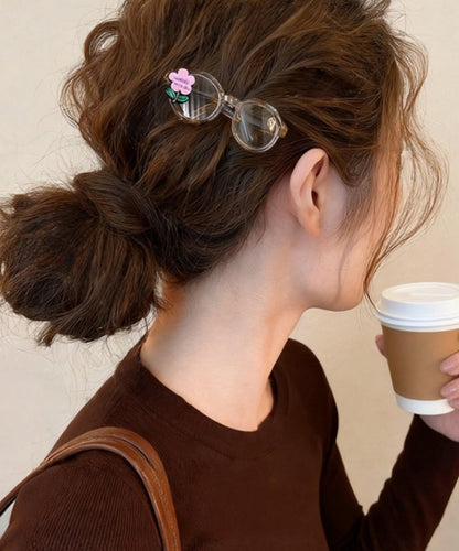 Bonitas gafas de acrílico rosa con diseño floral y horquilla para el pelo.