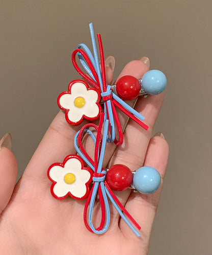 Un par de horquillas para el pelo con diseño de mariposas y flores de acrílico arcoíris