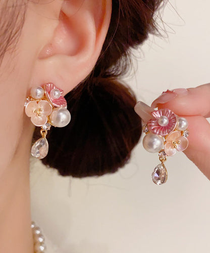 Lindos aretes colgantes de cobre dorado con circonitas, perlas y flores de agua.