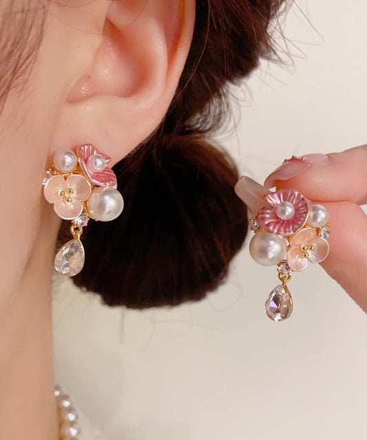 Lindos aretes colgantes de cobre dorado con circonitas, perlas y flores de agua.