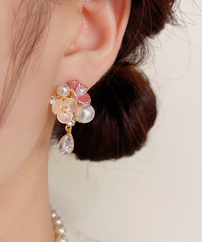 Lindos aretes colgantes de cobre dorado con circonitas, perlas y flores de agua.