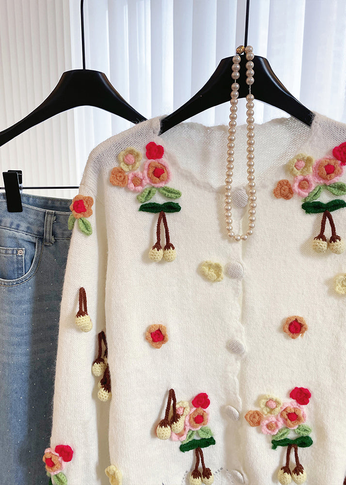 Niedliche, weiße, flauschige Bommel-verzierte, warme Strickjacke für den Winter