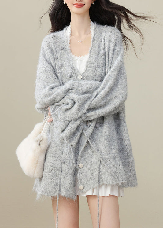 Elegante graue Strickjacke mit Bommelverzierung und Kordelzug für den Winter