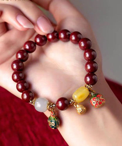 Elegante pulsera con dije de bestia dorada que traga arena morada y dorada