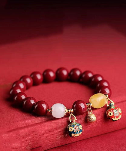 Elegante pulsera con dije de bestia dorada que traga arena morada y dorada