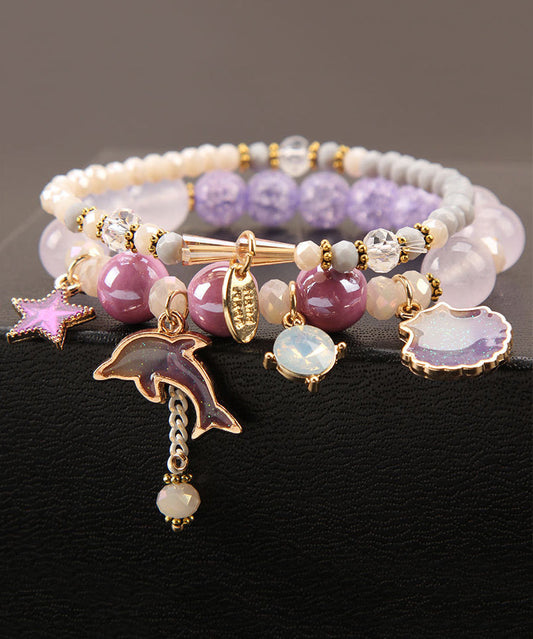 Elegante pulsera con dije de estrella de delfín y cristal esmaltado en color púrpura