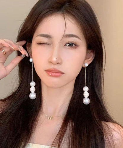 Elegantes pendientes colgantes con borlas de perlas doradas en plata de ley blanca