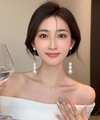 Elegantes pendientes colgantes con borlas de perlas doradas en plata de ley blanca