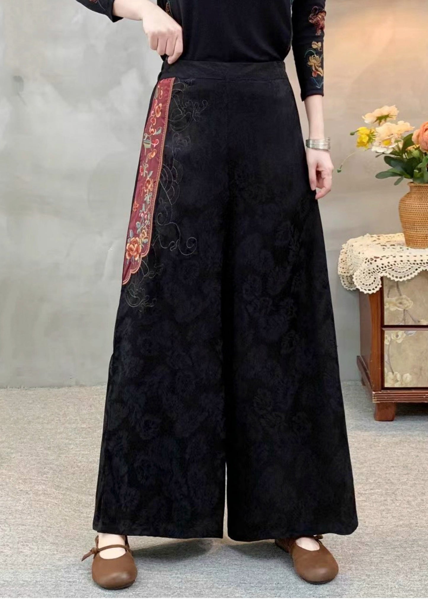 Schwarze Seidenhose im Ethno-Stil mit Stickereien und Patchwork-Muster für den Frühling