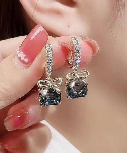 Pendientes colgantes con lazo de cristal y circonita dorada de color morado oscuro.