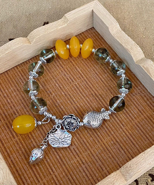 Modisches Bettelarmband aus Sterlingsilber mit Kristallen und kleinen Fischen, die mit einer Lotusblüte spielen