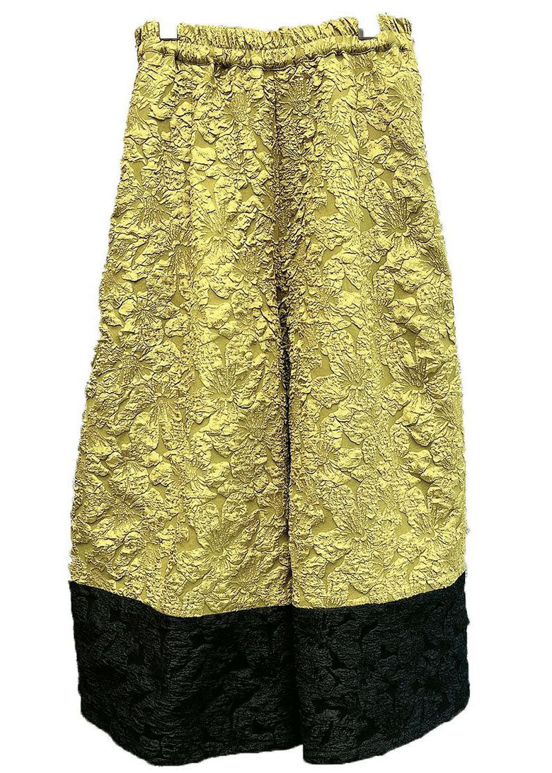 Pantalones anchos de seda con diseño de patchwork y bolsillos amarillos de moda para primavera.