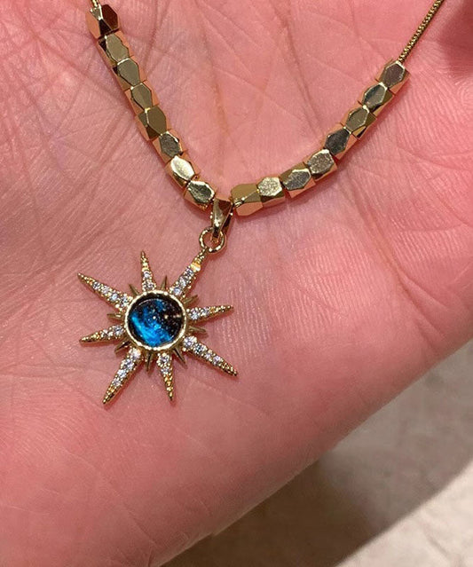 Halskette mit Anhänger in Form eines acht bärtigen Sterns aus Zirkonia, verziert mit feinem, blau-kupferfarbenem, vergoldetem Zirkon.