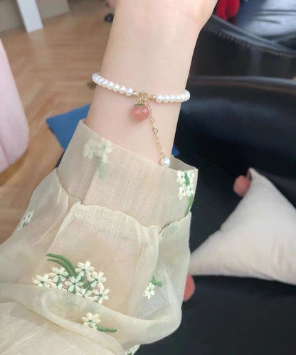 Feines Charm-Armband aus weißer Legierung mit honig-pfirsichfarbenen Perlen